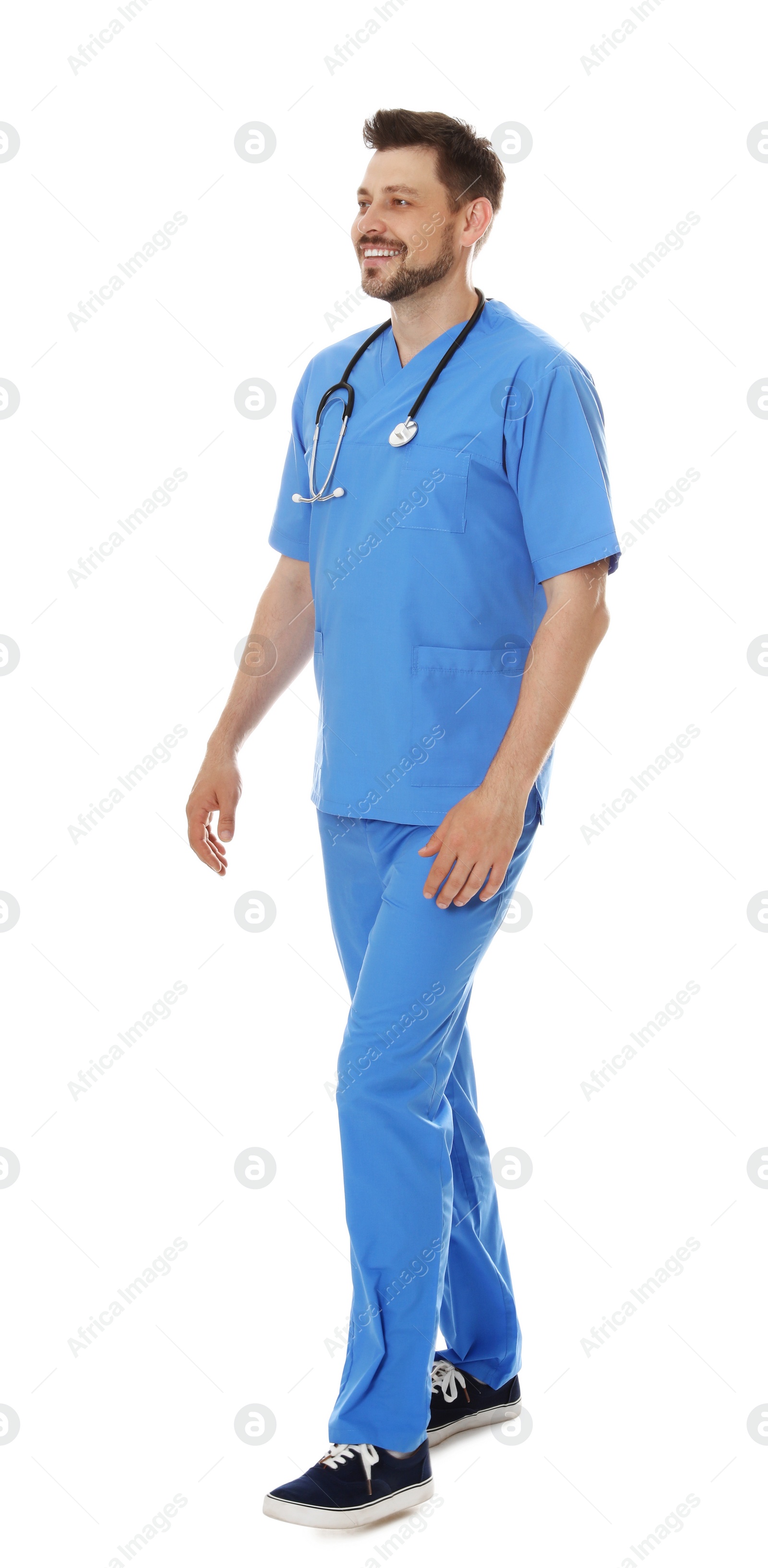 Photo of Full length portrait of smiling male doctor in scrubs isolated on white. Medical staff