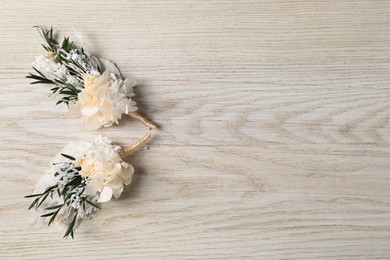 Photo of Stylish boutonnieres on white wooden table, top view. Space for text