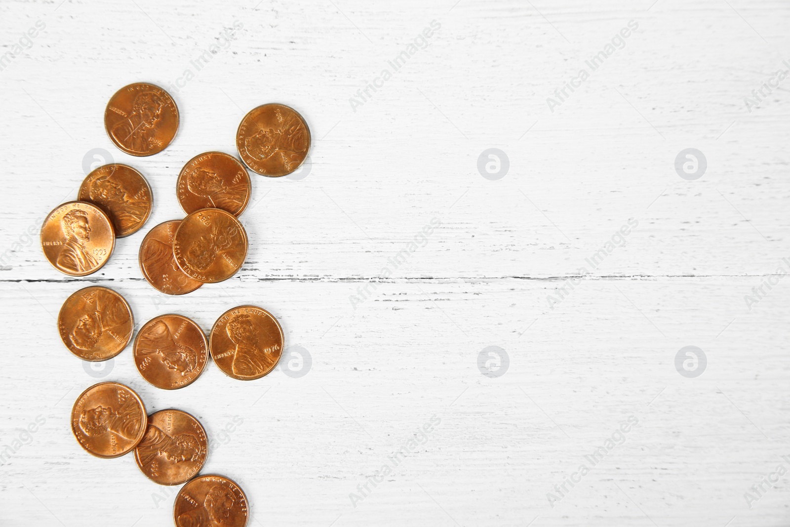 Photo of Many coins on wooden table, top view. Space for text