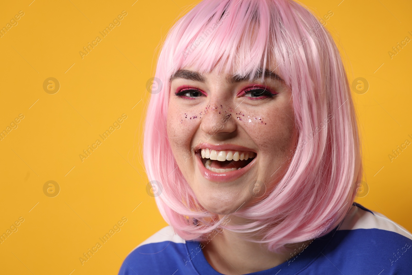 Photo of Happy woman with bright makeup and glitter freckles on yellow background. Space for text