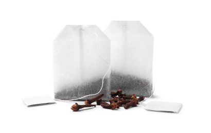 Tea bags and cloves on white background