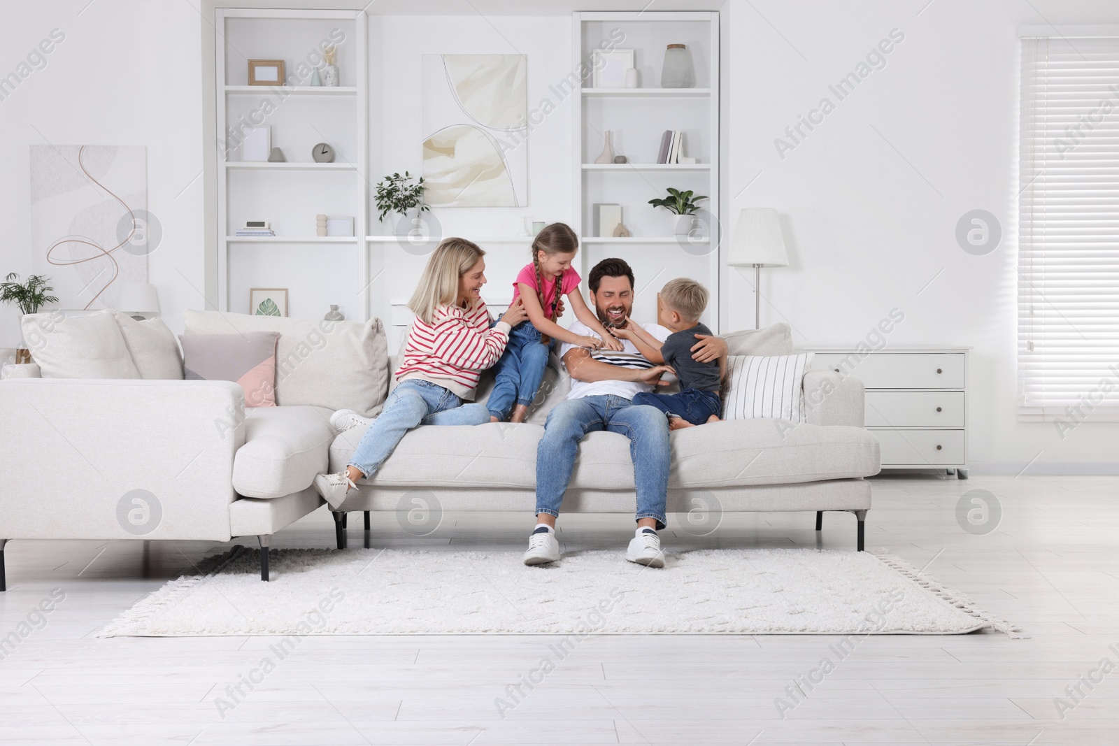 Photo of Happy family having fun together on sofa at home