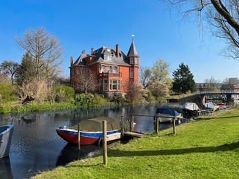 Beautiful city canal with moored boats on sunny spring day