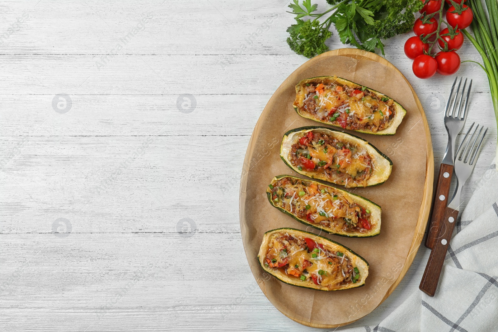 Photo of Flat lay composition with delicious stuffed zucchini on white wooden table. Space for text