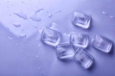 Photo of Ice cubes on color background, top view. Space for text