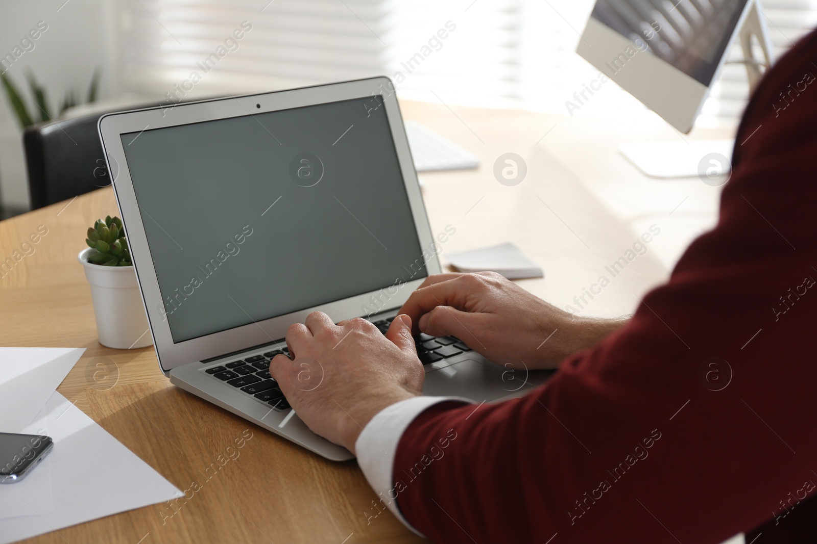 Photo of Freelancer working on laptop at table indoors, closeup