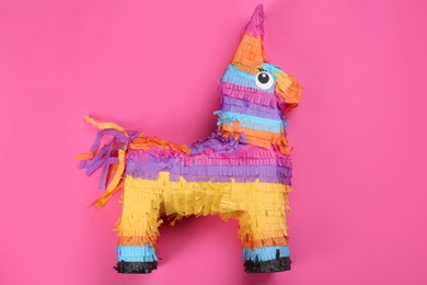 Bright donkey pinata on pink background, top view