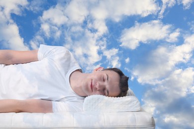 Man sleeping on orthopedic pillow against blue sky