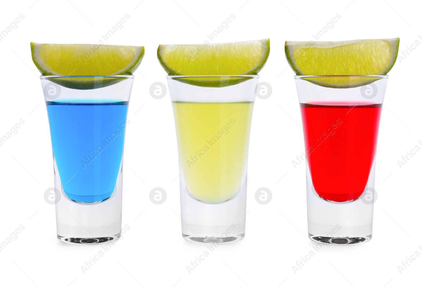 Photo of Different shooters in shot glasses and lime wedges isolated on white. Alcohol drink