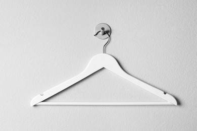 Photo of Empty wooden clothes hanger on white wall