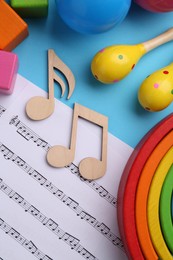 Tools for creating baby songs. Flat lay composition with wooden notes and maracas on light blue background