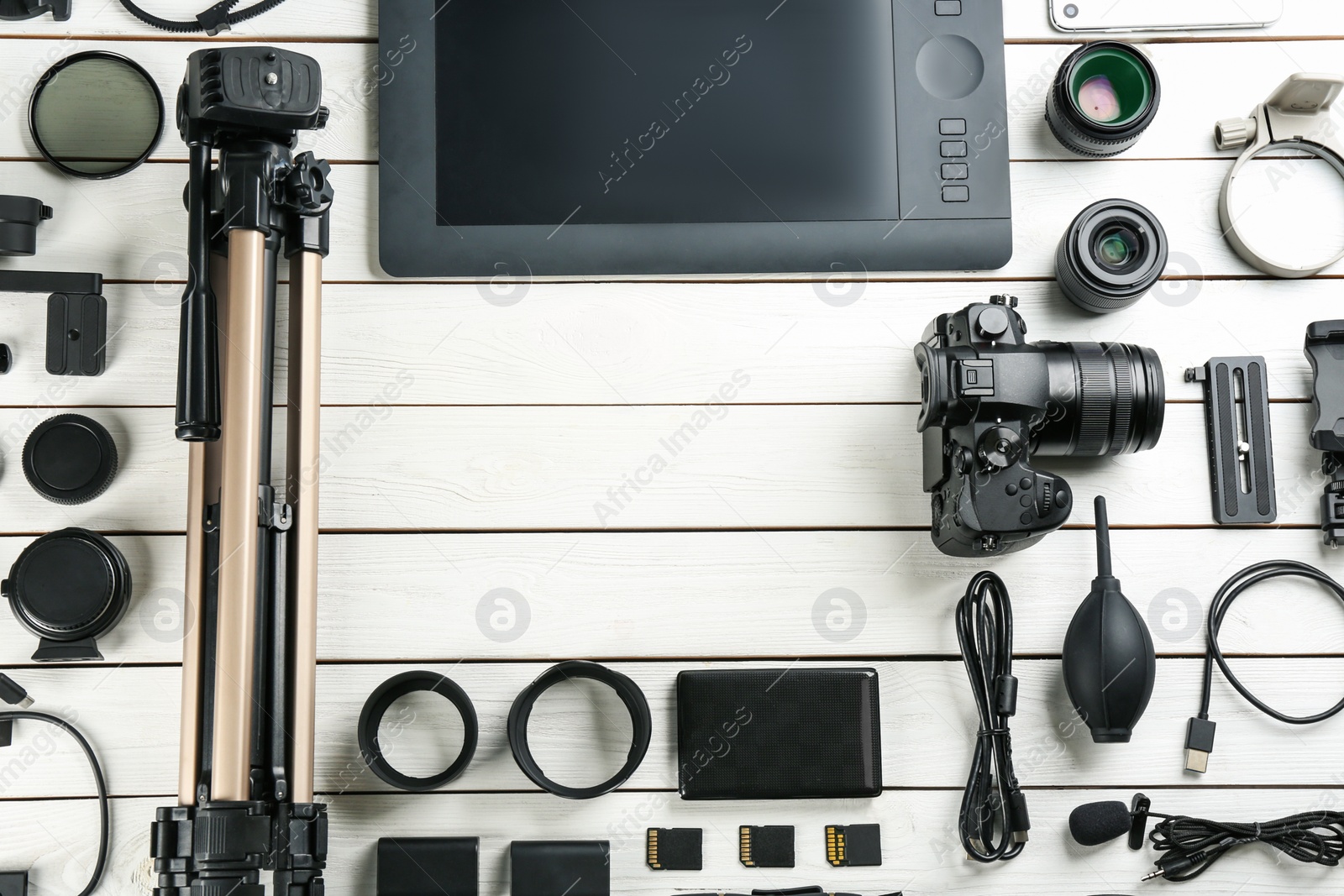 Photo of Flat lay composition with camera and video production equipment on white wooden table. Space for text