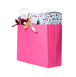Pink paper shopping bag full of gift boxes on white background
