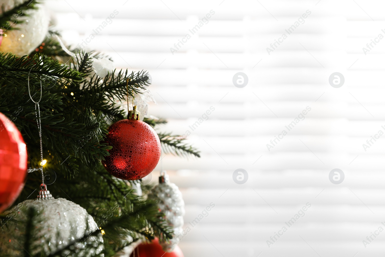 Photo of Beautifully decorated Christmas tree near window indoors, closeup. Space for text