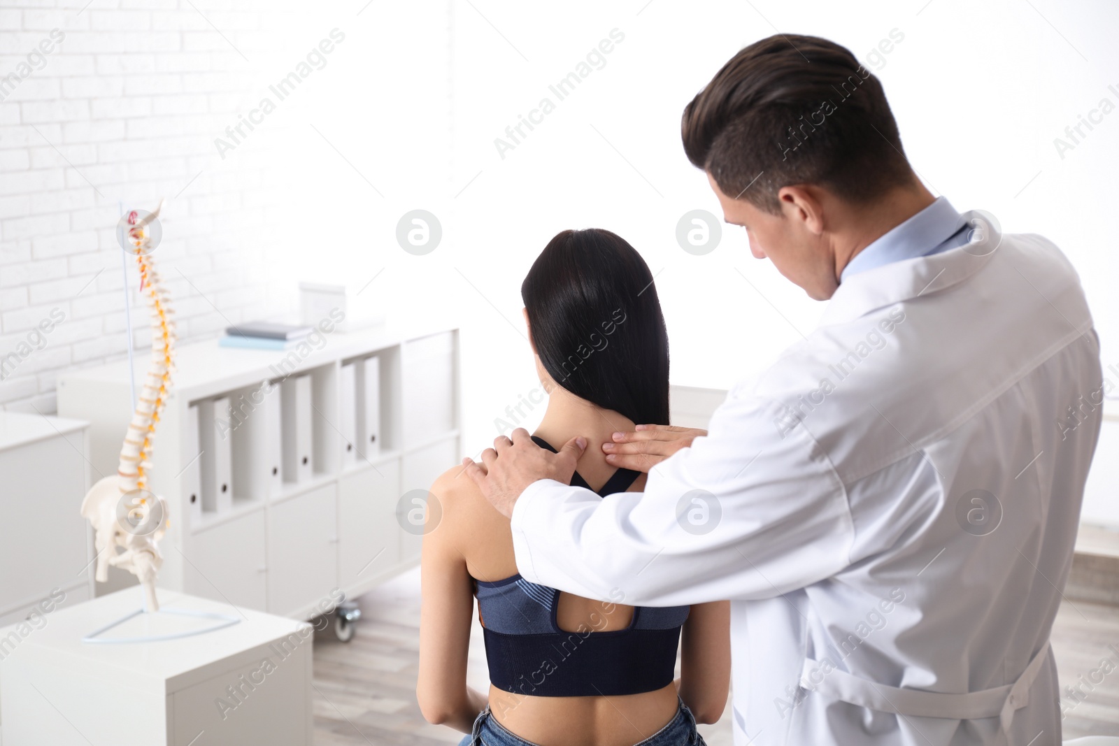 Photo of Professional orthopedist examining woman in medical office