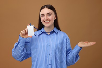 Photo of Happy woman with blank badge on brown background