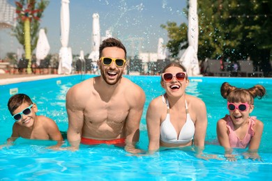 Photo of Happy family in swimming pool on sunny day