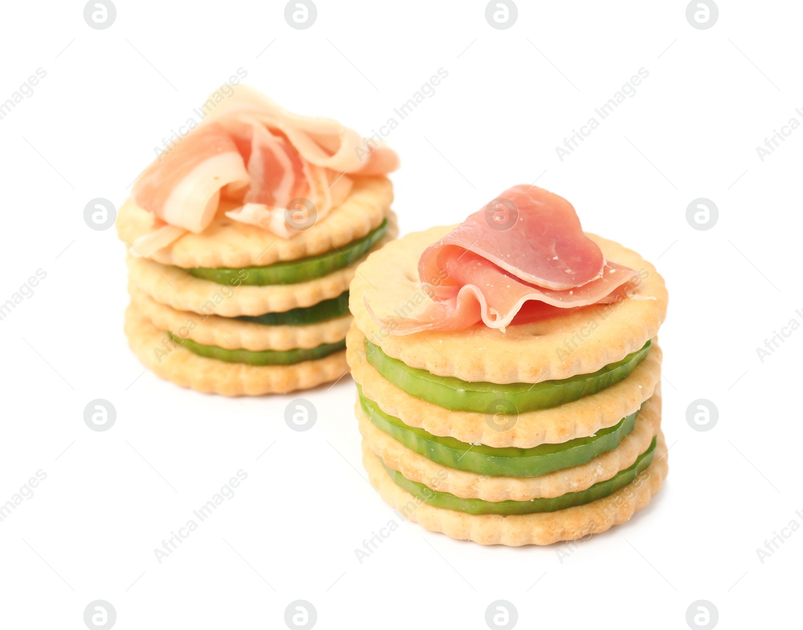 Photo of Delicious crackers with cucumber and prosciutto on white background