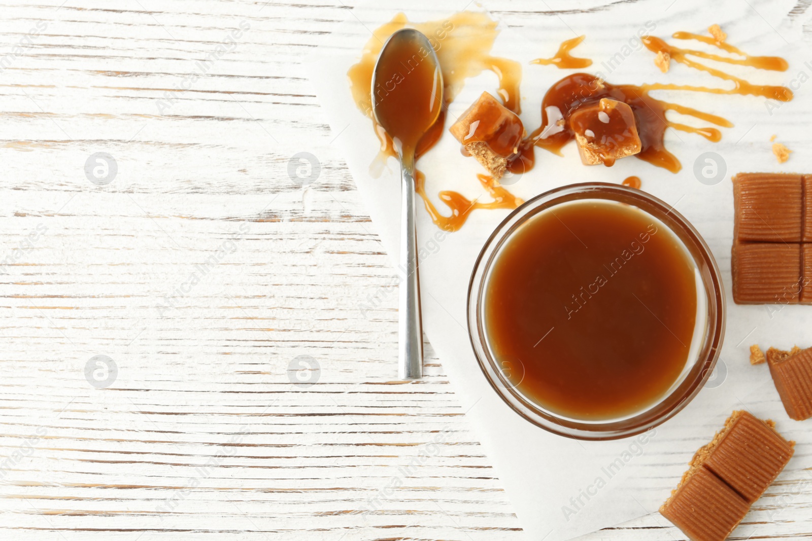 Photo of Delicious candies with caramel sauce on table, top view