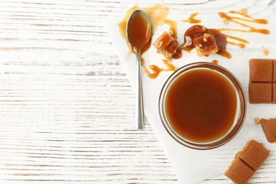 Delicious candies with caramel sauce on table, top view