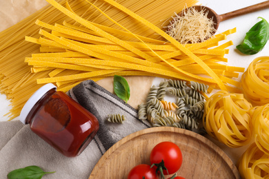 Flat lay composition with different types of pasta on white table