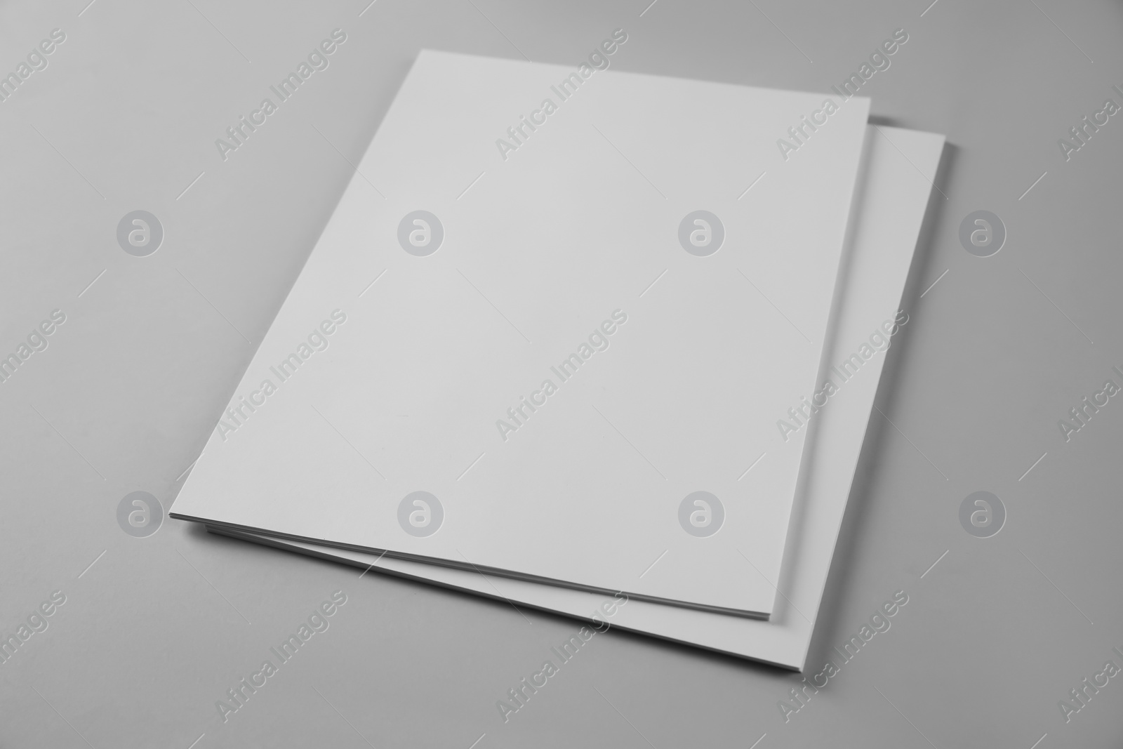 Photo of Blank brochures on grey background. Mockup for design