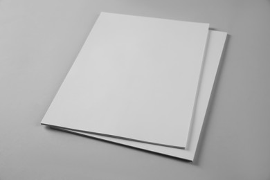 Photo of Blank brochures on grey background. Mockup for design