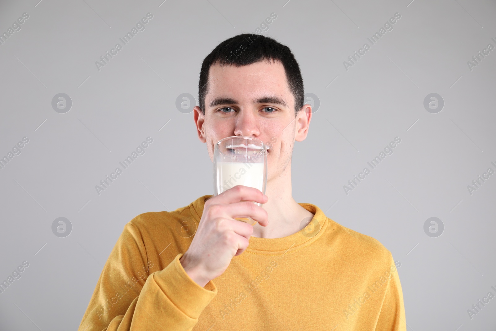 Photo of Milk mustache left after dairy product. Man drinking milk on gray background