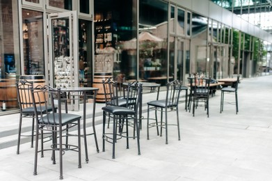 Photo of Beautiful cafe with dark stylish furniture outdoors