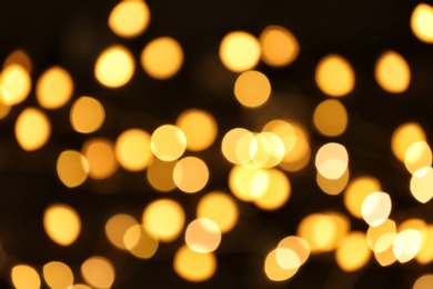 Photo of Beautiful golden lights on dark background. Bokeh effect