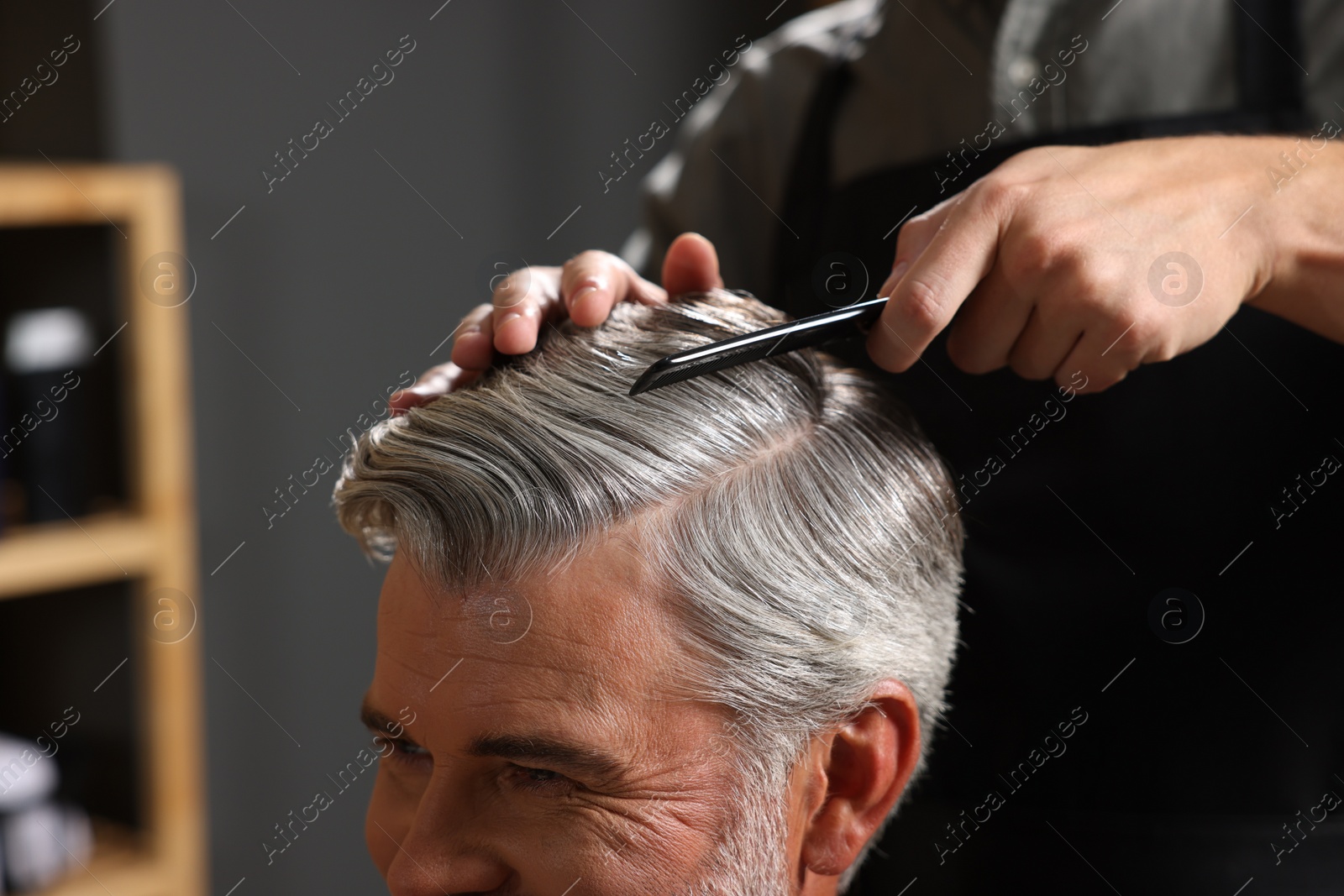 Photo of Hair styling. Professional hairdresser working with client in barbershop, closeup