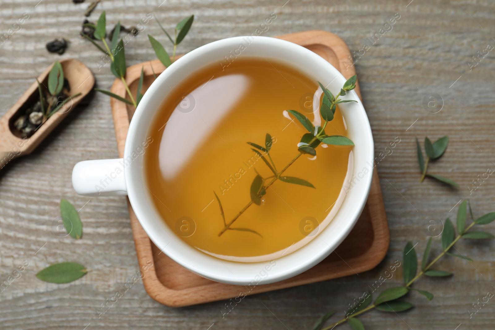 Photo of Cup of aromatic eucalyptus tea on wooden table, flat lay