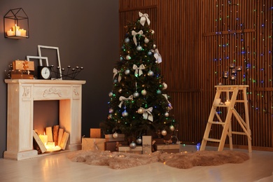 Photo of Stylish room interior with Christmas tree and decorative fireplace