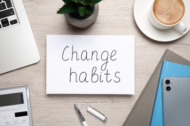 Photo of Flat lay composition of paper note with phrase Change Habits on white wooden table