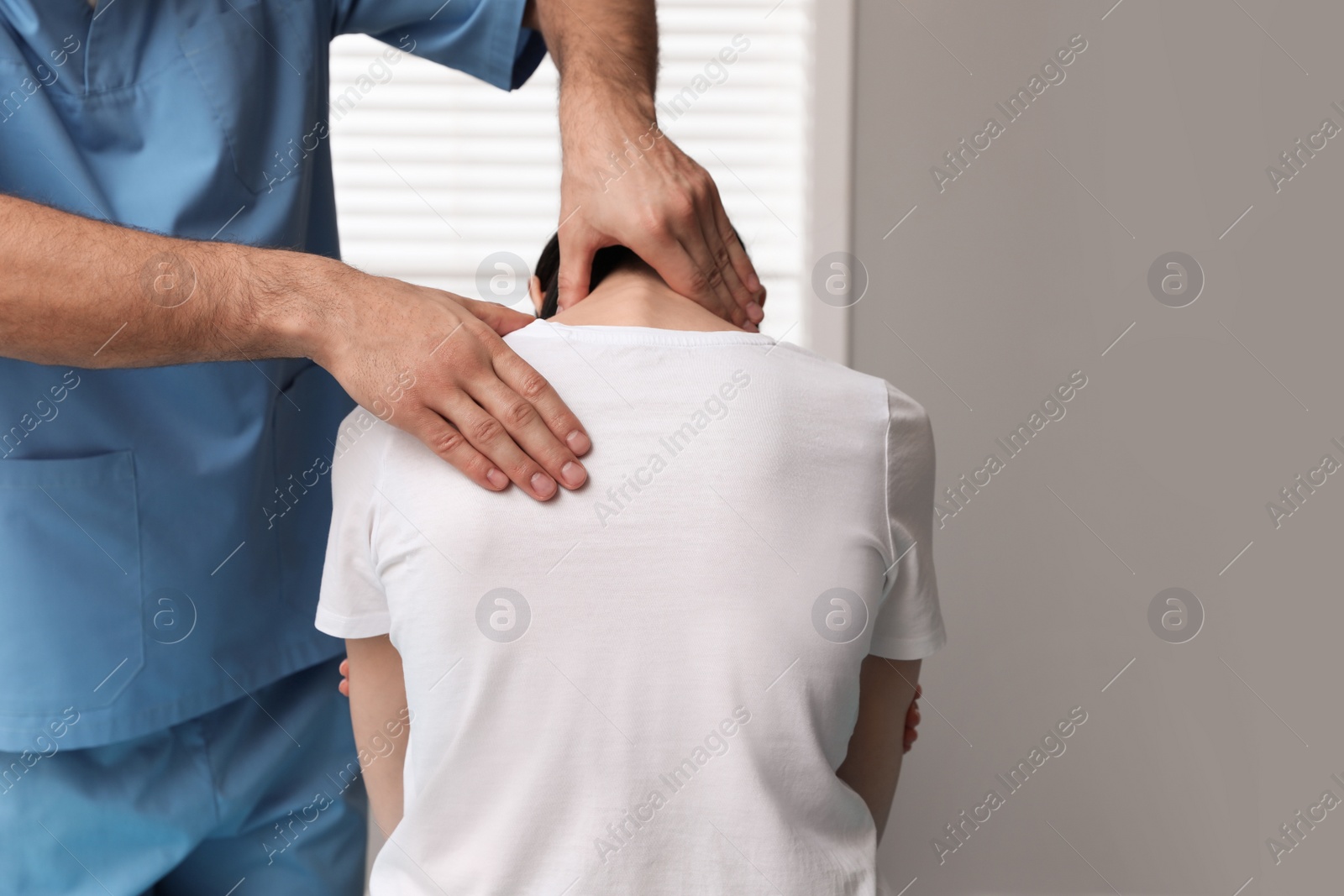 Photo of Orthopedist examining woman's neck in clinic, closeup. Scoliosis treatment