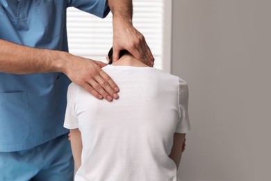 Photo of Orthopedist examining woman's neck in clinic, closeup. Scoliosis treatment