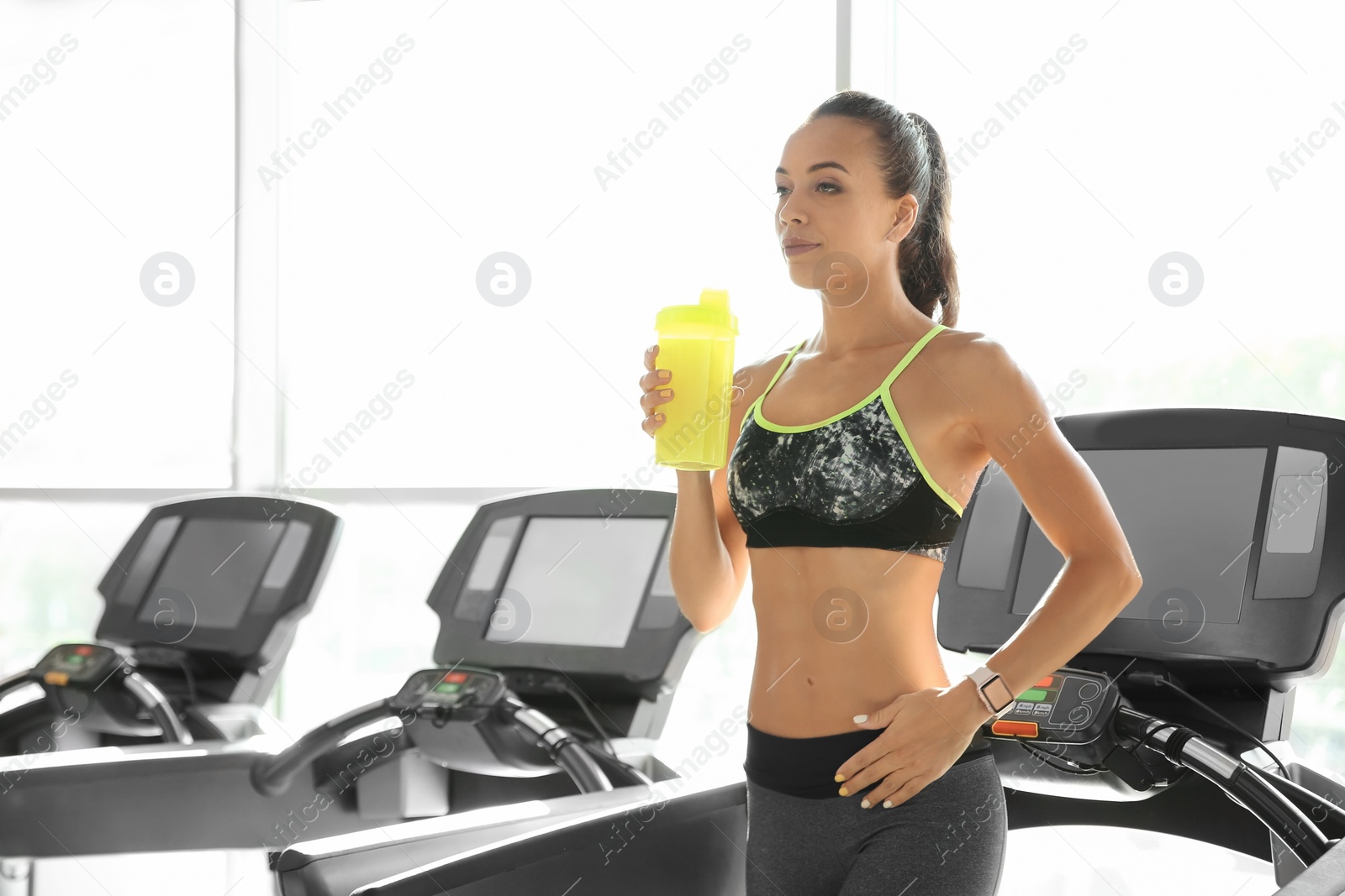 Photo of Portrait of athletic woman with protein shake in gym