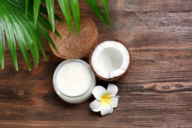 Photo of Beautiful composition with coconut oil and nuts on wooden background