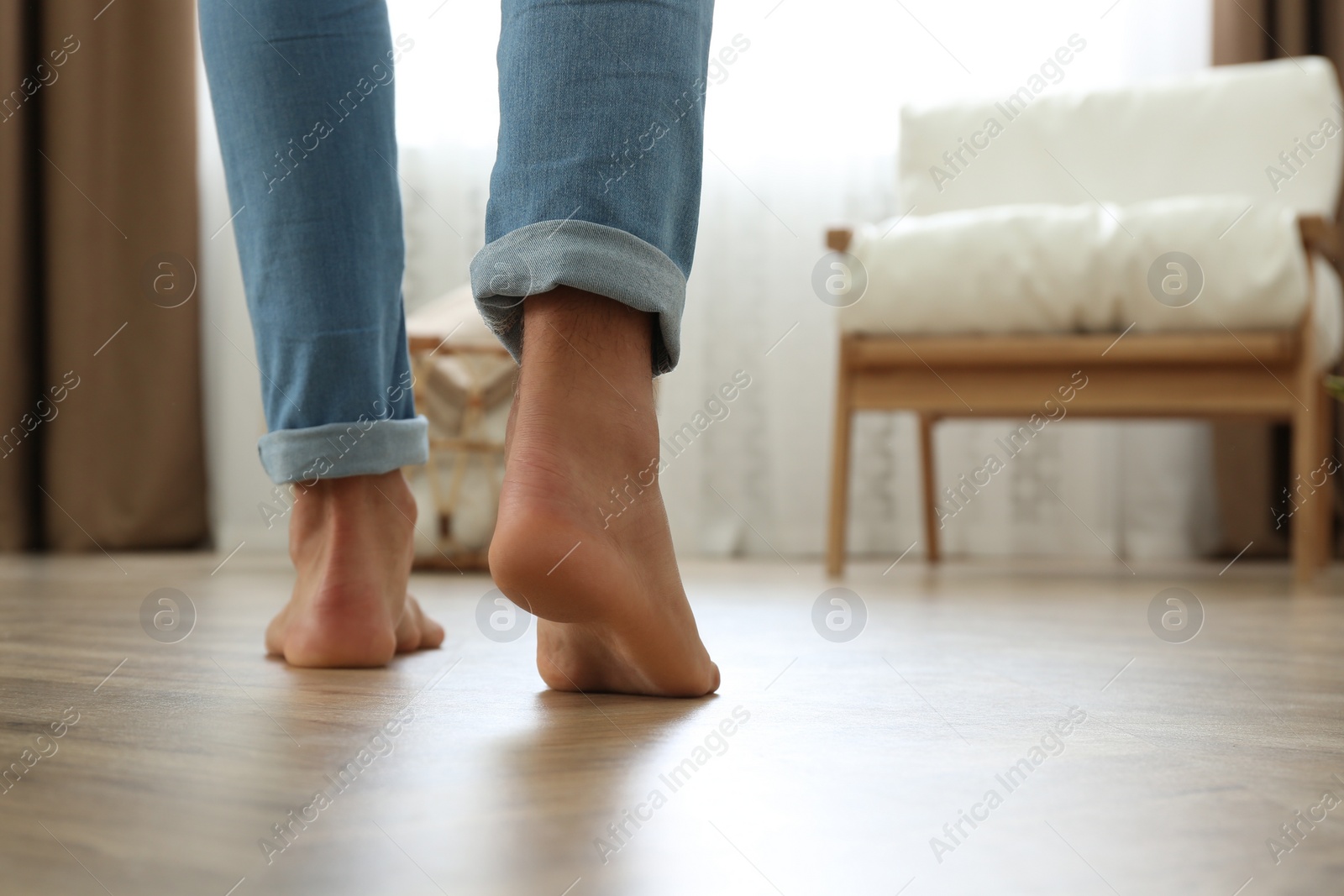 Photo of Man walking barefoot at home, space for text. Floor heating concept