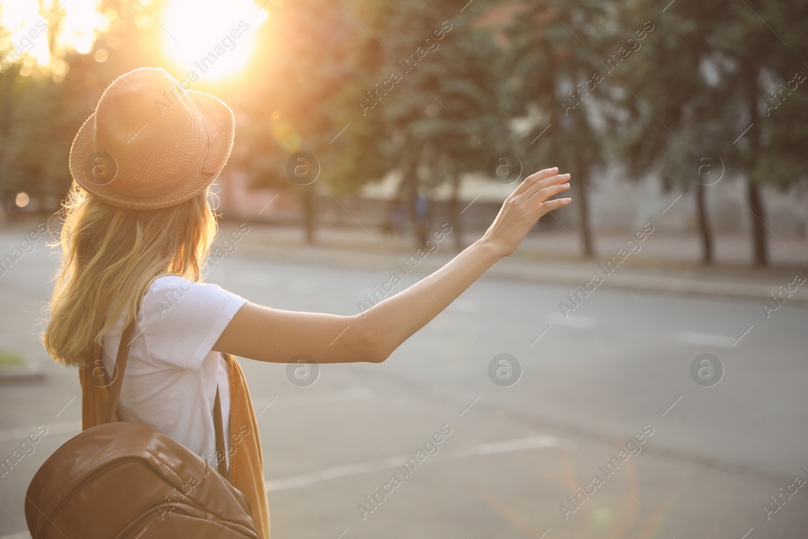 Photo of Young woman catching taxi on city street