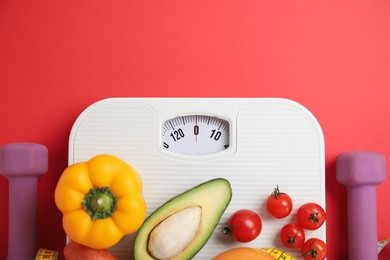 Photo of Flat lay composition with scales and healthy food on red background, space for text