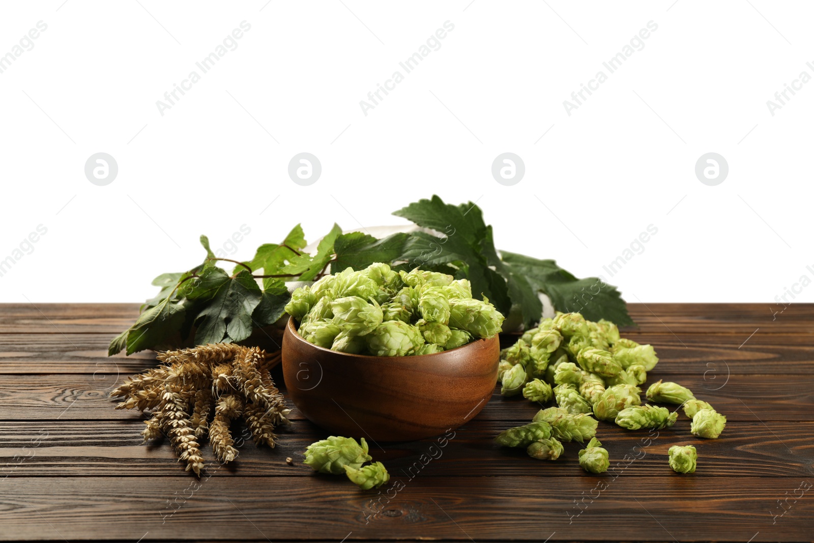 Photo of Fresh hop flowers and wheat ears on wooden table against white background