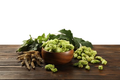 Fresh hop flowers and wheat ears on wooden table against white background