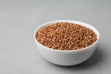 Photo of Buckwheat grains in bowl on grey table