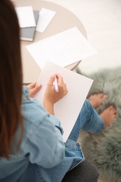 Photo of Woman writing letter at home, closeup view