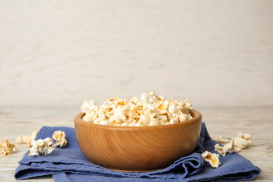 Photo of Tasty pop corn on white wooden table