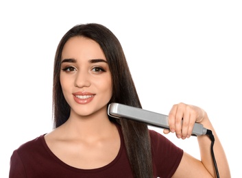 Happy woman using hair iron on white background