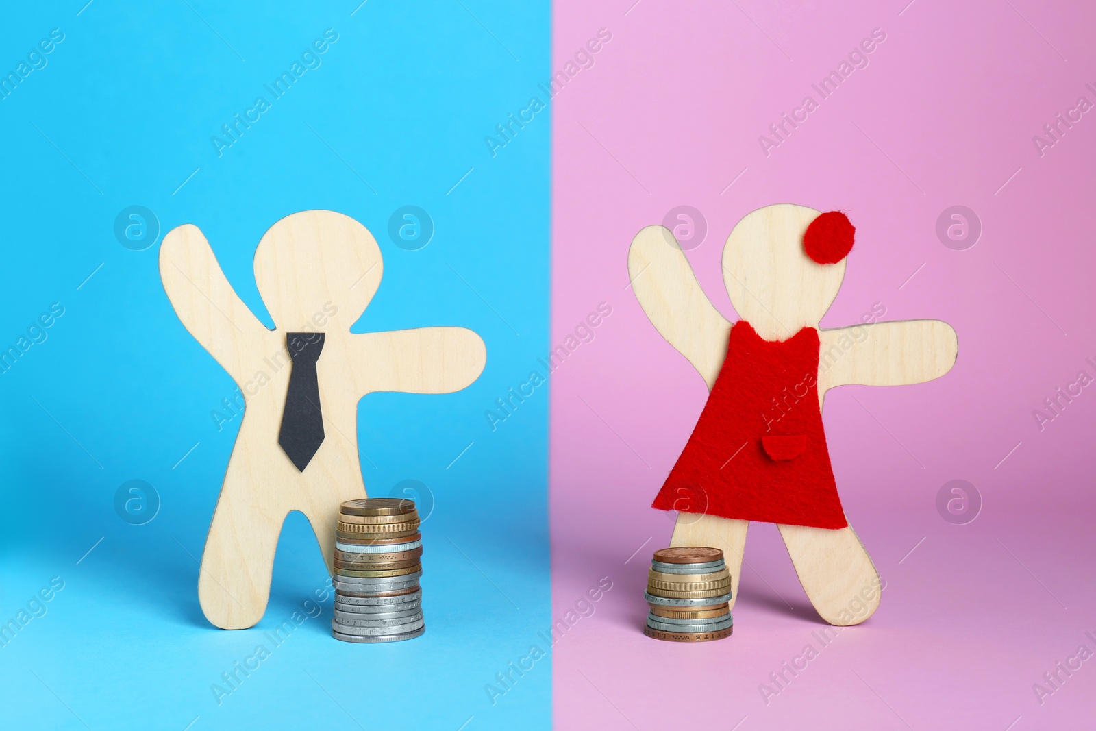 Photo of Gender pay gap. Wooden figures of man and woman with stacked coins on color background