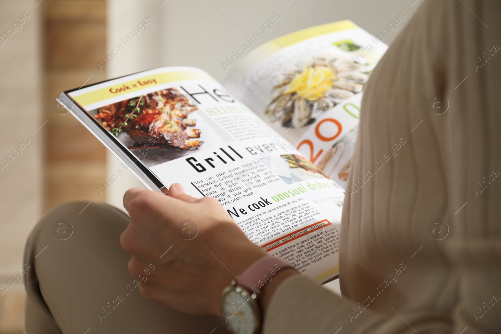 Photo of Woman reading cooking magazine indoors, closeup view