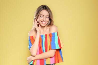 Photo of Portrait of beautiful smiling woman in stylish clothes on yellow background